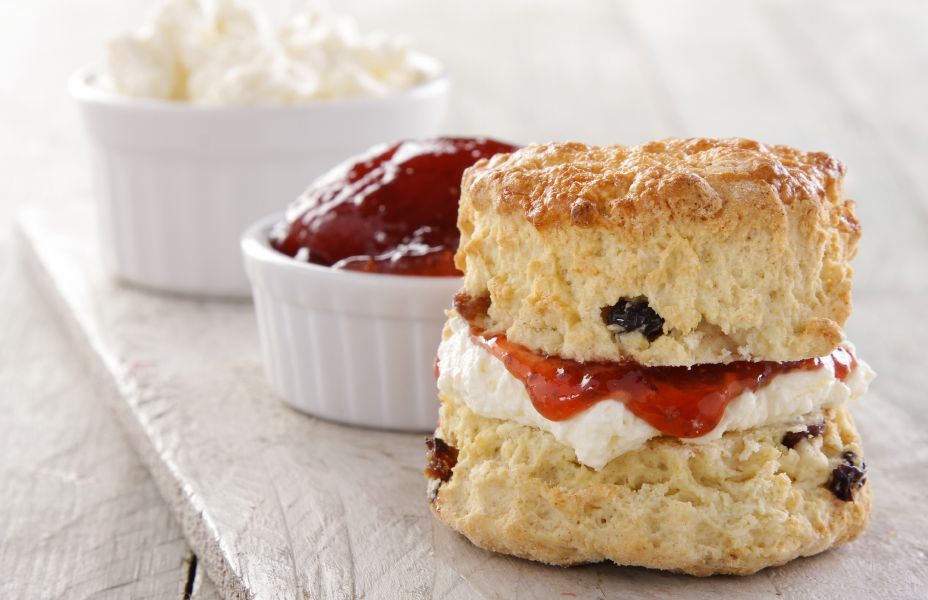 close up image of a cream and jam scone